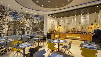 Un restaurant moderne avec un comptoir central, un espace salon et une fresque murale.
