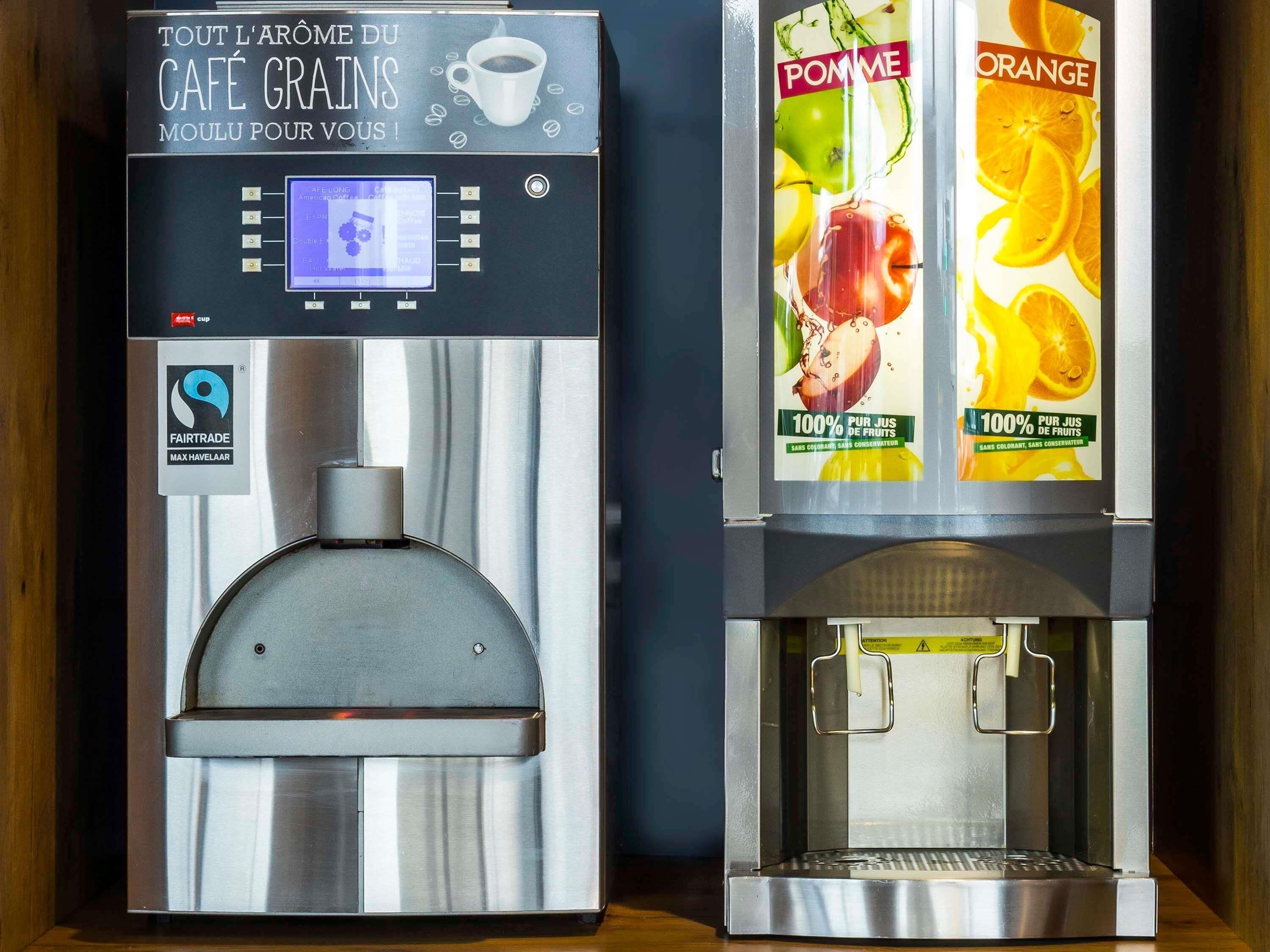 Dos máquinas de café con pantallas digitales y carteles con motivos de frutas.