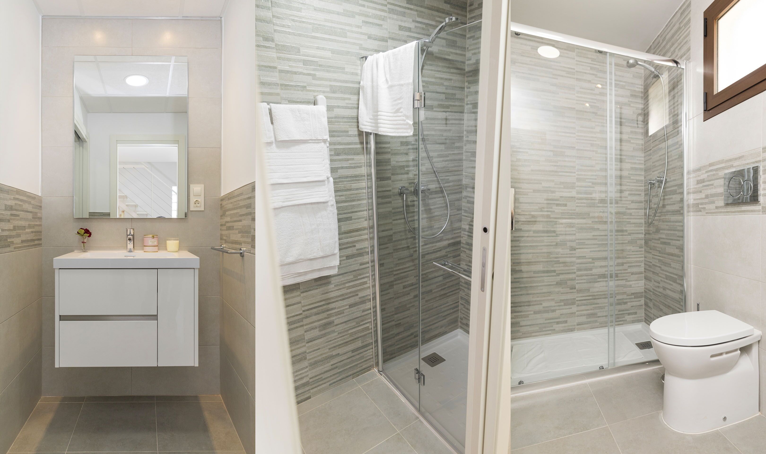 A modern bathroom with a glass-enclosed shower, a white sink with a mirror, and a toilet.