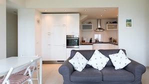 A modern living room with a grey sofa and a dining table with striped cushions. - Contemporary 3 Bed Italian Lakes Villa, Lake Views, Wifi, BBQ (Massino Visconti)