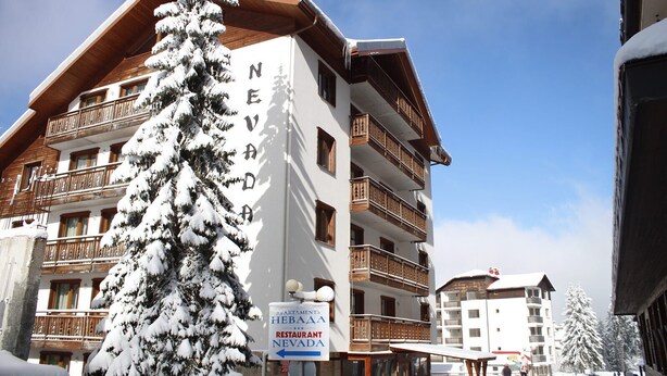 A multi-story hotel with balconies and a sign indicating a restaurant named "Nevada".