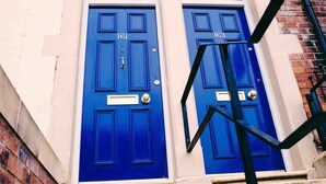 A building with two blue doors, numbered 161 and 163, and a small window above the doors. - Coalminer's Cottage (Gateshead)