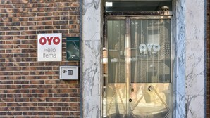 Entrada de hotel con un cartel que dice "OYO Hello Ifema" y un teclado de cierre.