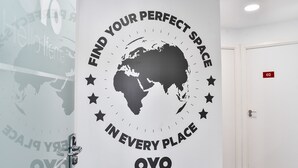 Una pared con un cartel motivacional que dice “Encuentra tu espacio ideal en cada lugar” y la palabra “OYO” en la parte inferior.