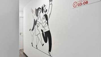 Un pasillo con un mural que muestra a dos personas bailando.
