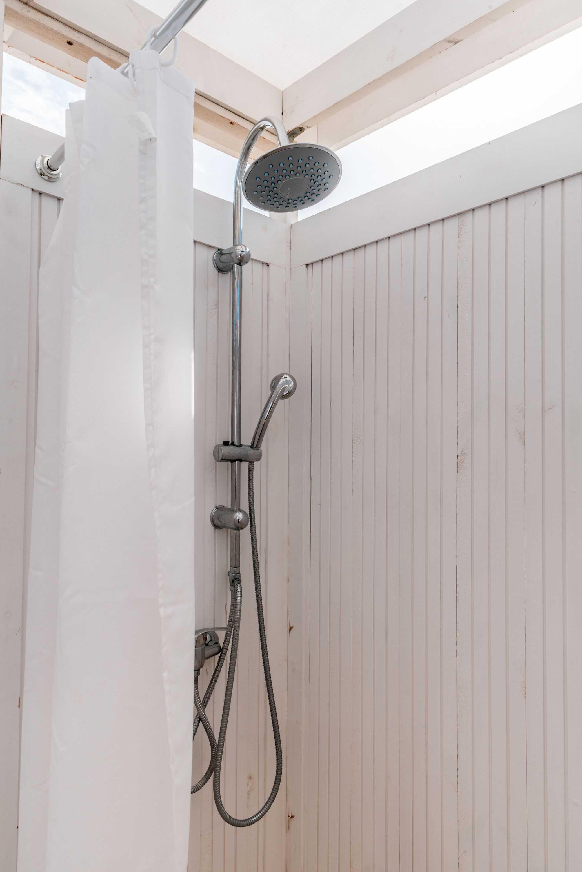 A shower with a handheld showerhead and a flexible hose.