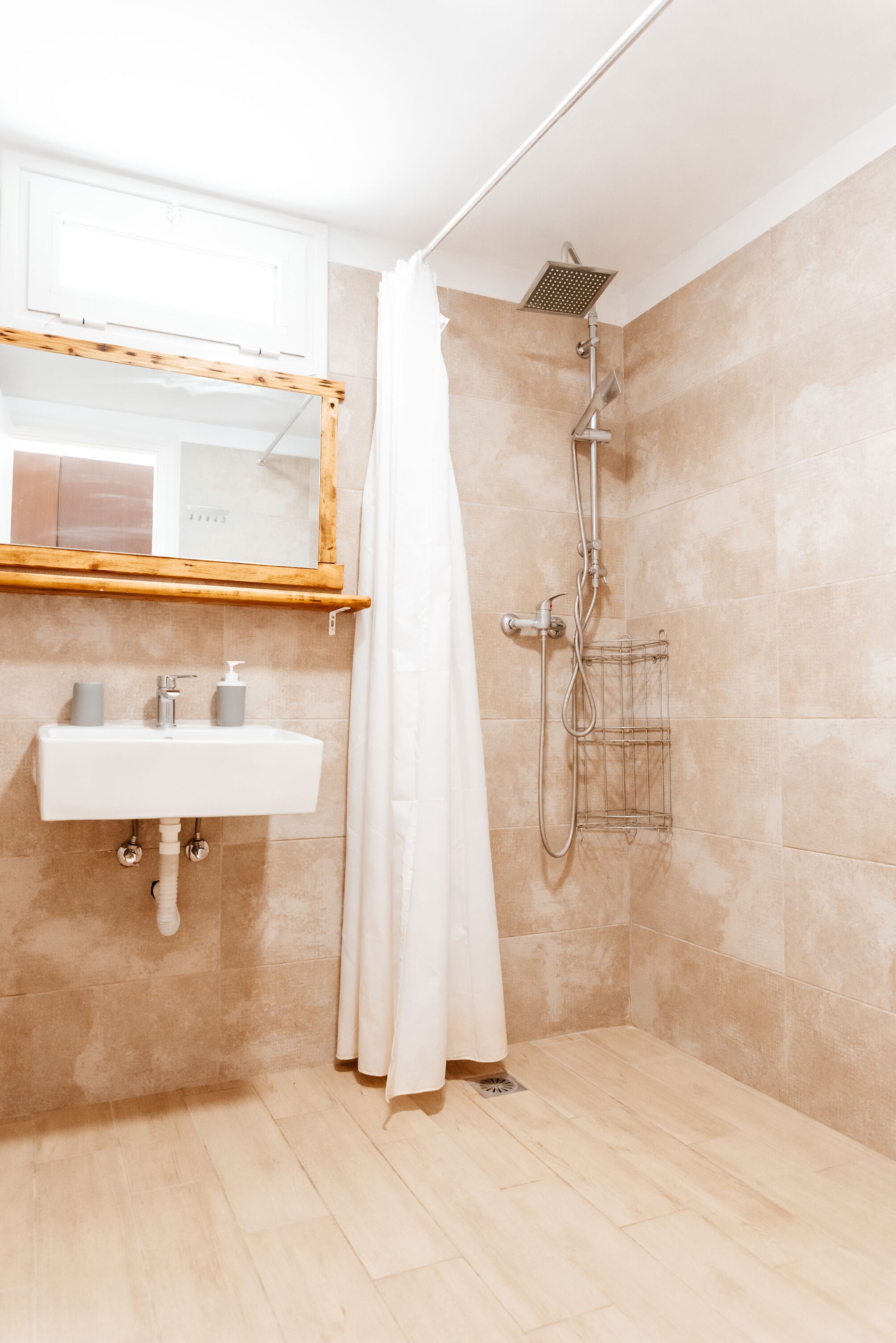 Un baño moderno con ducha, lavabo y espejo.