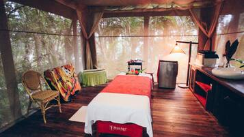 Relax in this serene room with a large bed, comfortable chair, and a sink with mirror.