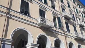 Un edificio de varios pisos con balcones, arcos y un cielo azul despejado.
