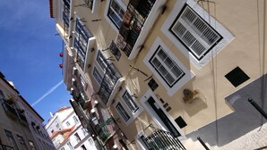 Una estrecha calle adoquinada bordeada de edificios con balcones y ventanas.