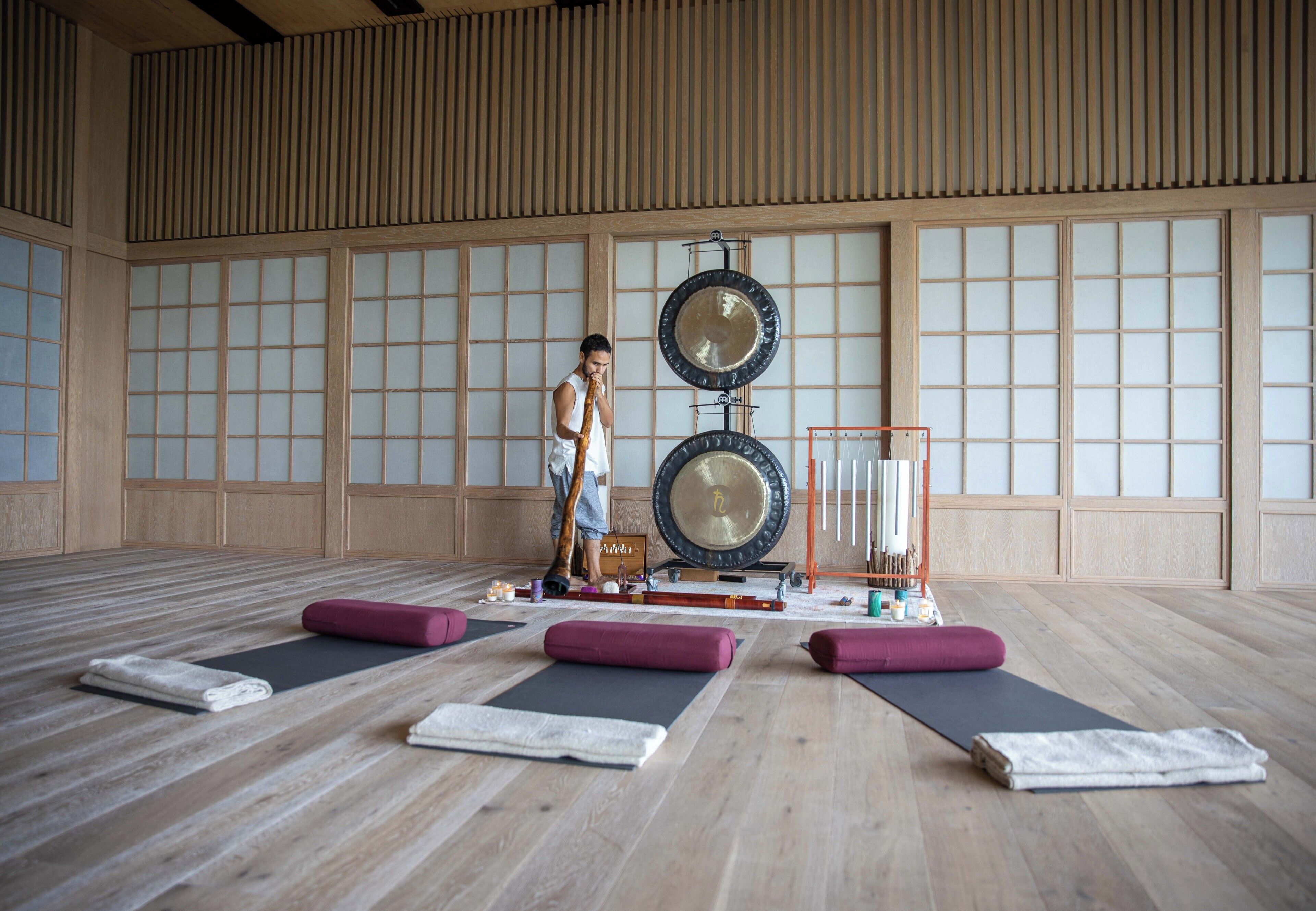 Una habitación amplia con esteras de tatami, un gran techo de madera y una estética japonesa tradicional.