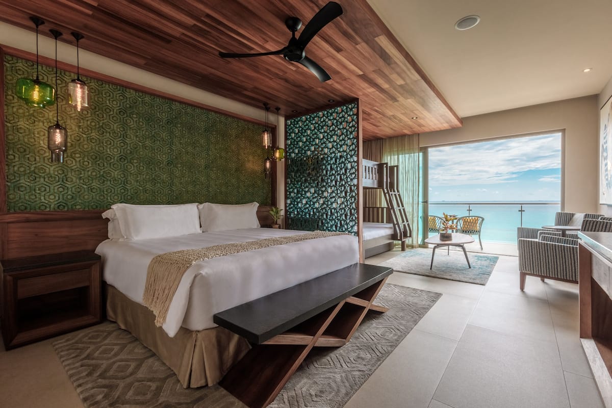 Un dormitorio moderno con una cama grande, techo de madera y vista al mar.