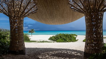 A beach view with a thatched canopy structure.