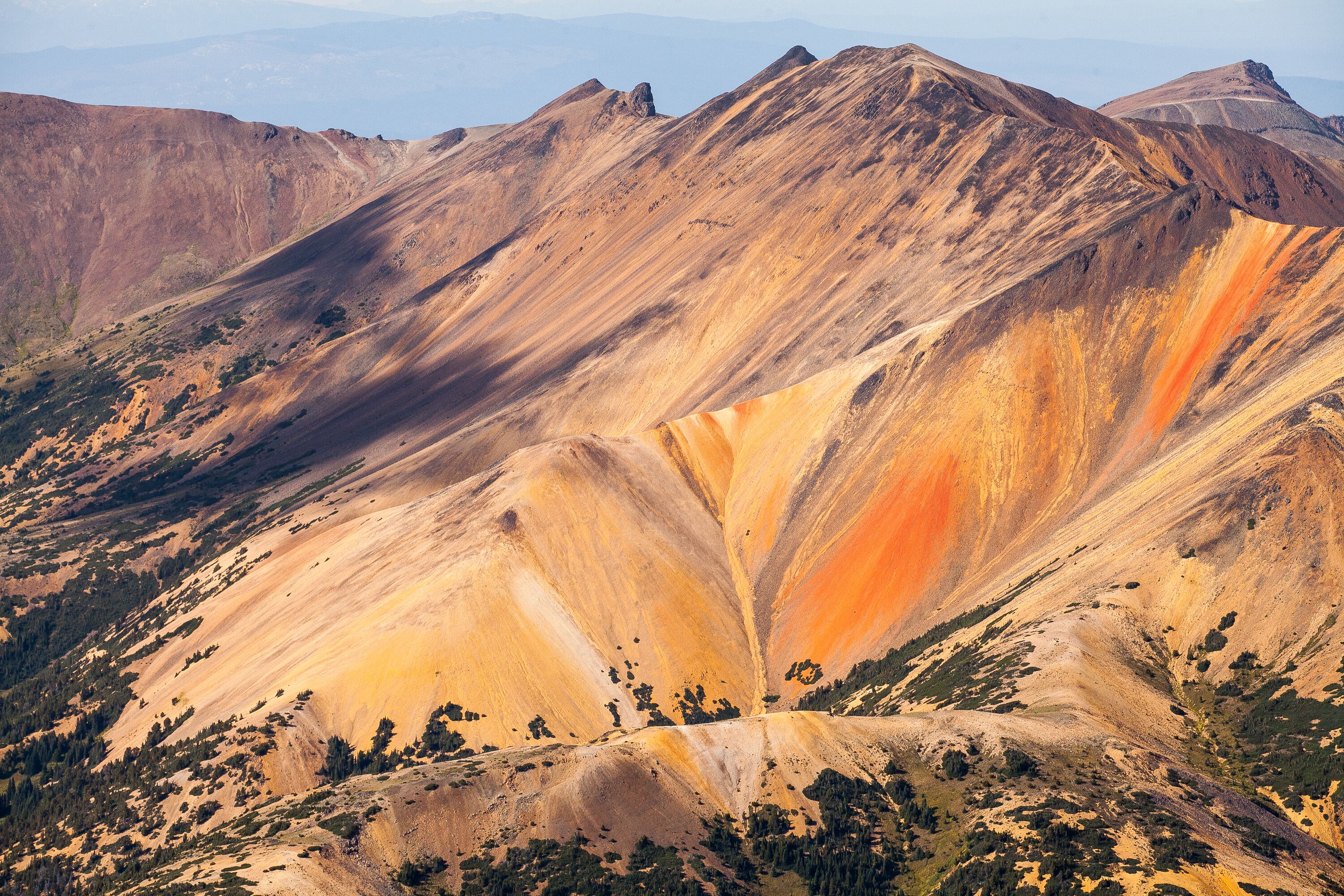 Paisagem montanhosa com formações geológicas marcantes e vegetação escassa.