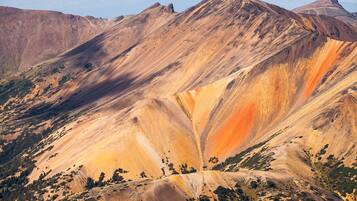 Paisagem montanhosa com formações geológicas marcantes e vegetação escassa.