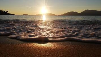 A beach with waves at sunset.