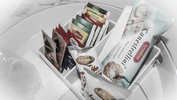 A tray with various packaged snacks and a container of chocolate.
