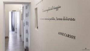 A hallway with a sign reading "BEACH" and a quote by Anne Carson on the wall. - L'Approdo Dell' Ammiraglio (La Spezia)