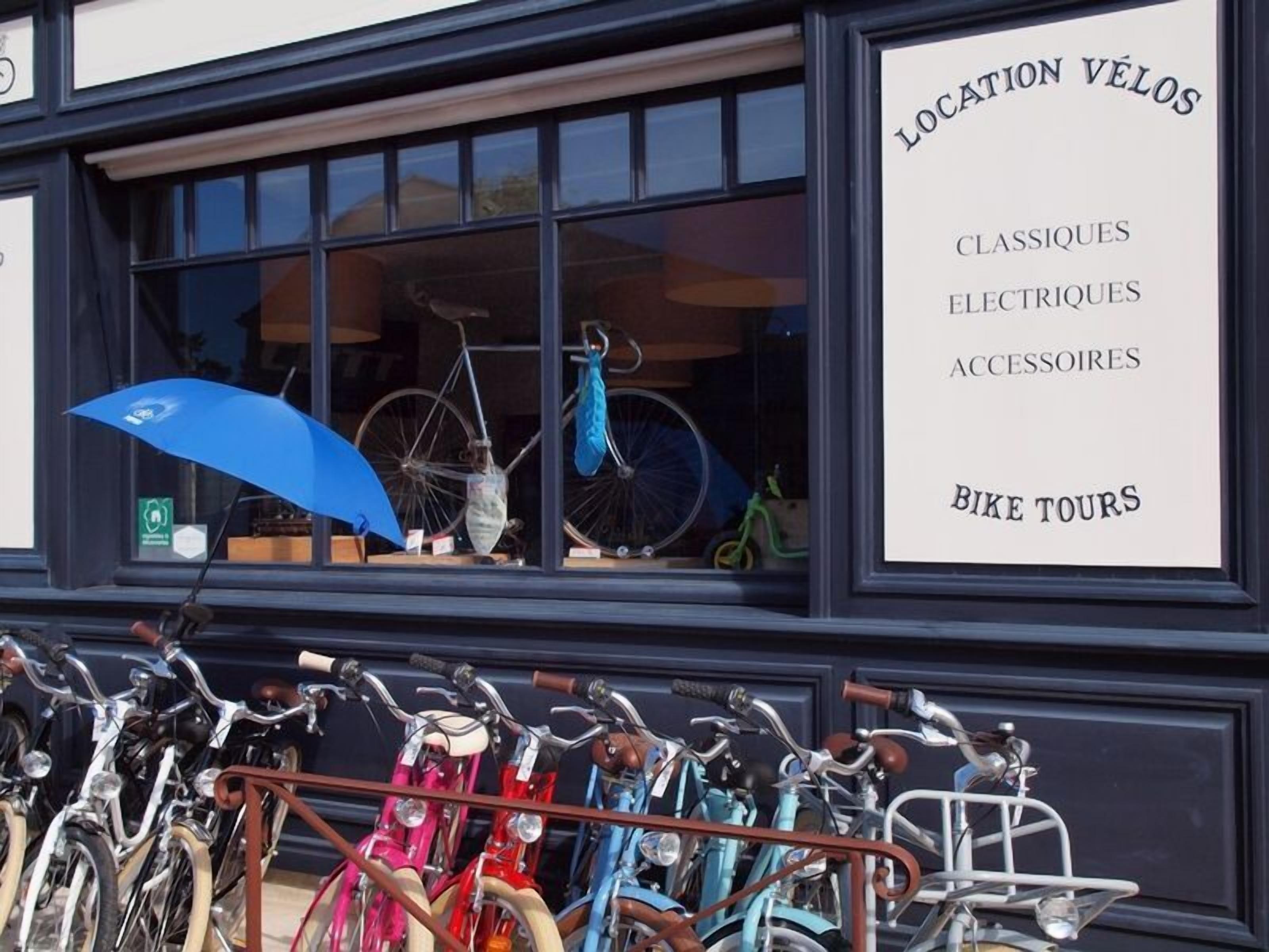 A storefront with a sign listing 'LOCATION VÉLOS' and 'CLASSIQUES ELECTRIQUES ACCESSOIRES BIKE TOURS'.