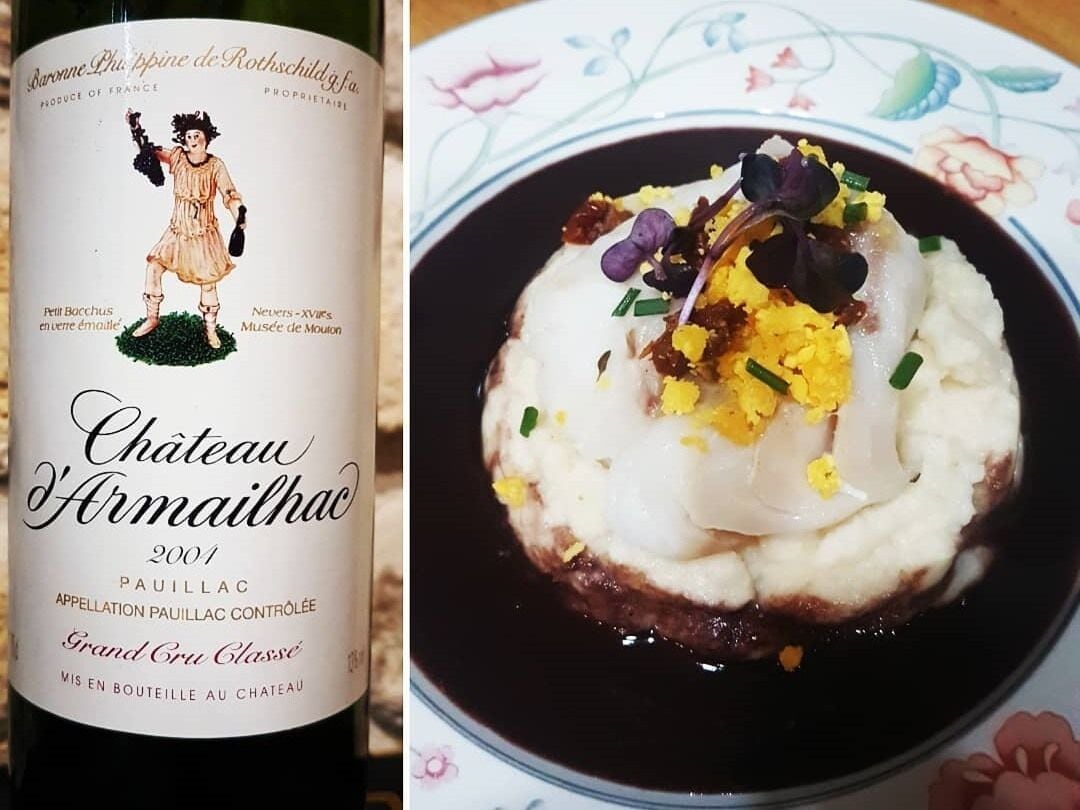 Eine Flasche Chateau Armailhac 2001 Wein und ein Gericht mit pochierten Eiern und Beilagen.