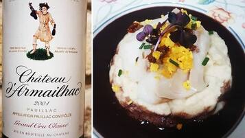 Eine Flasche Chateau Armailhac 2001 Wein und ein Gericht mit pochierten Eiern und Beilagen.