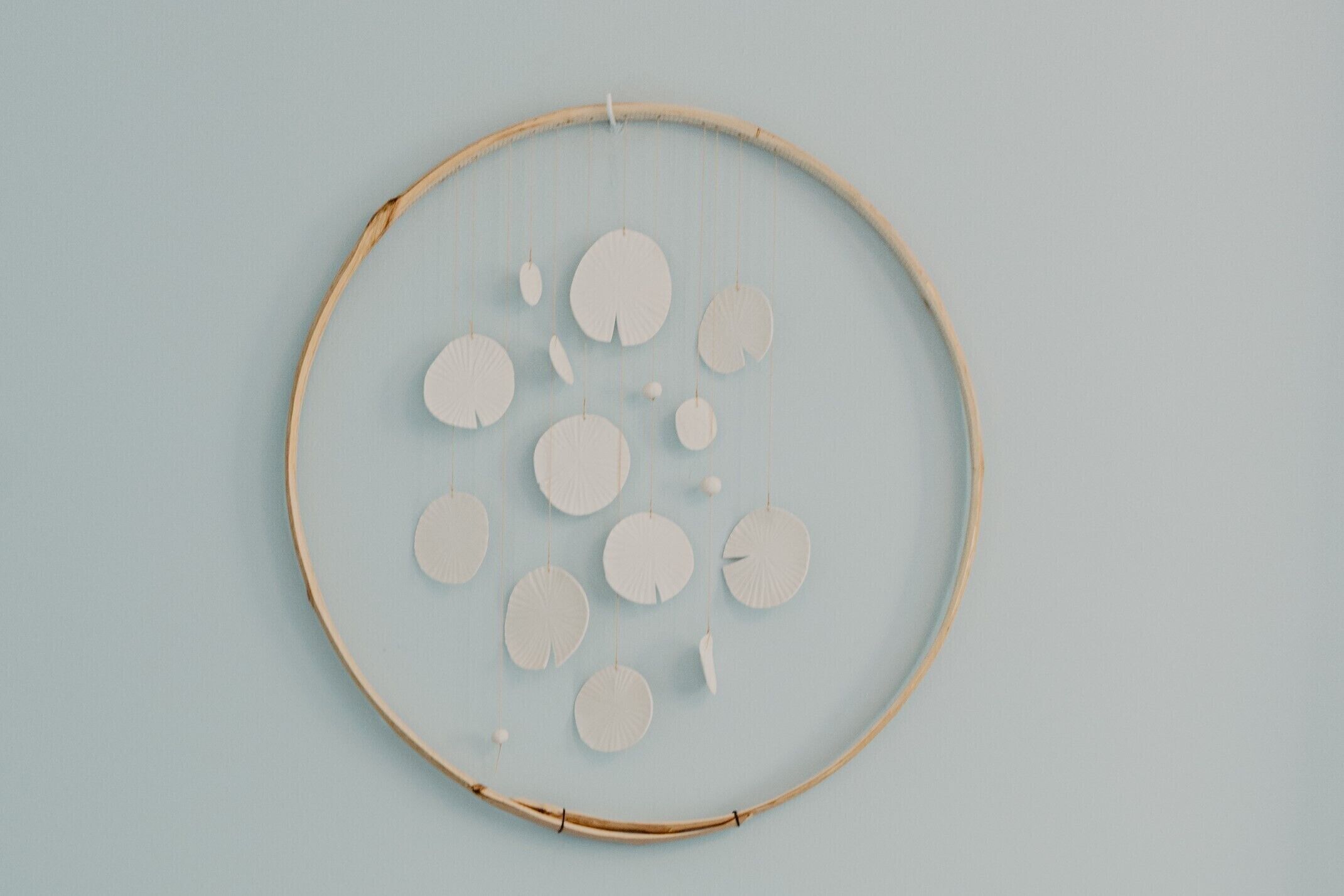 A circular wooden frame with hanging circular objects.