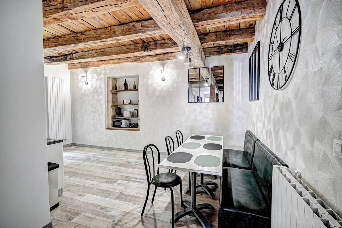 Un espace repas doté d’un plafond en bois, d’une grande horloge et d’un aménagement pour s’asseoir.