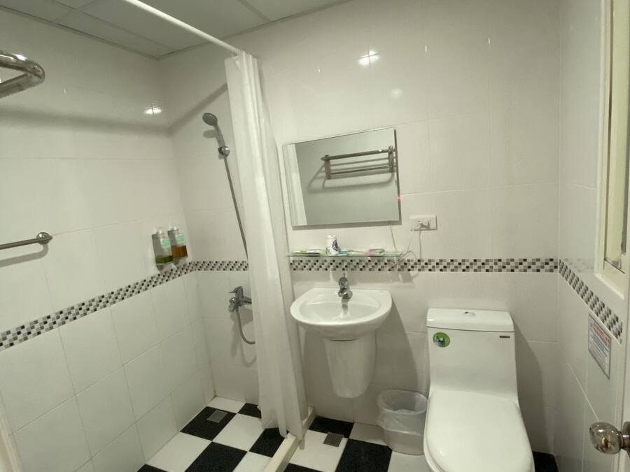 A bathroom with a black and white checkered floor, a white sink, and a toilet.