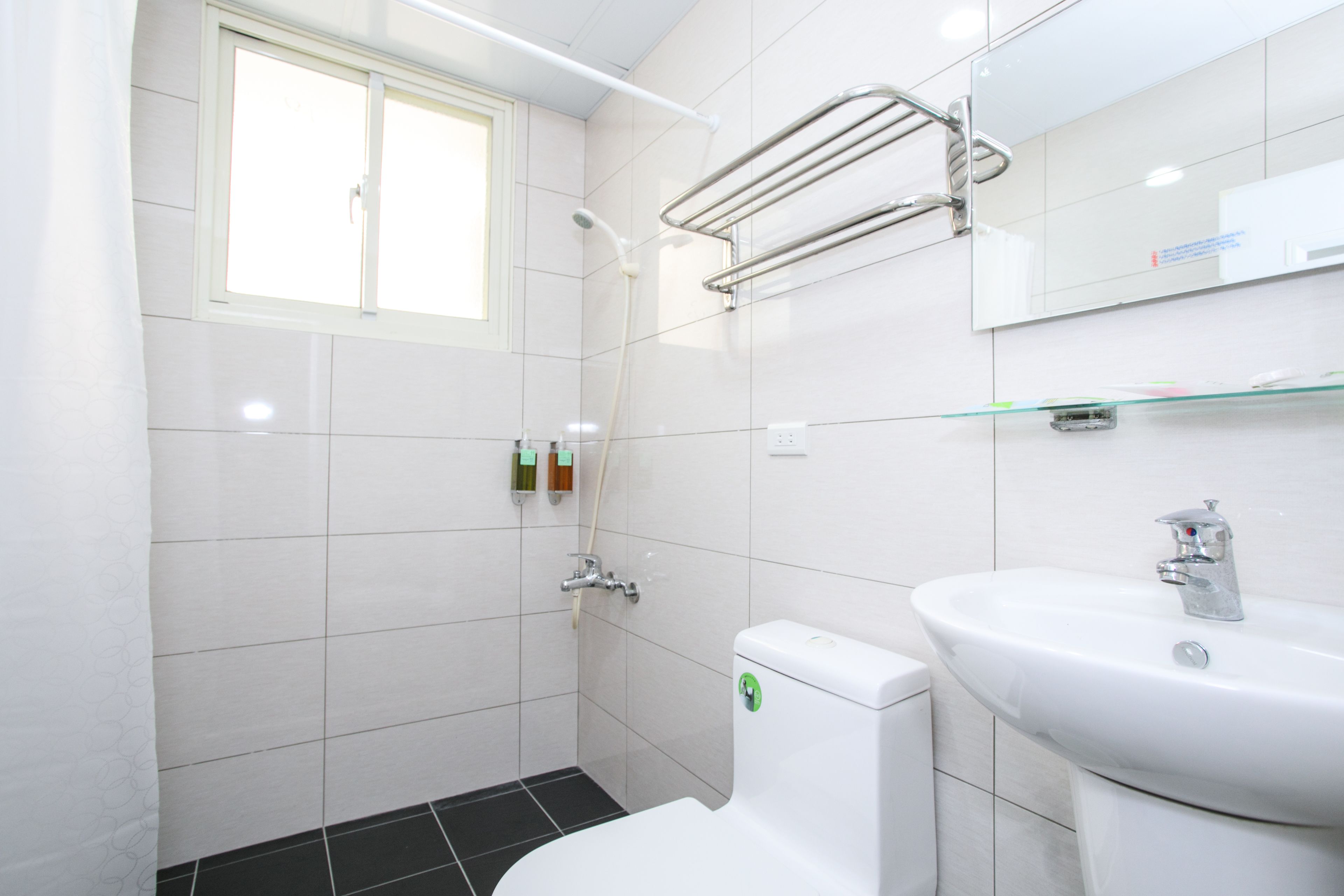 A modern bathroom with a toilet, sink, and shower.