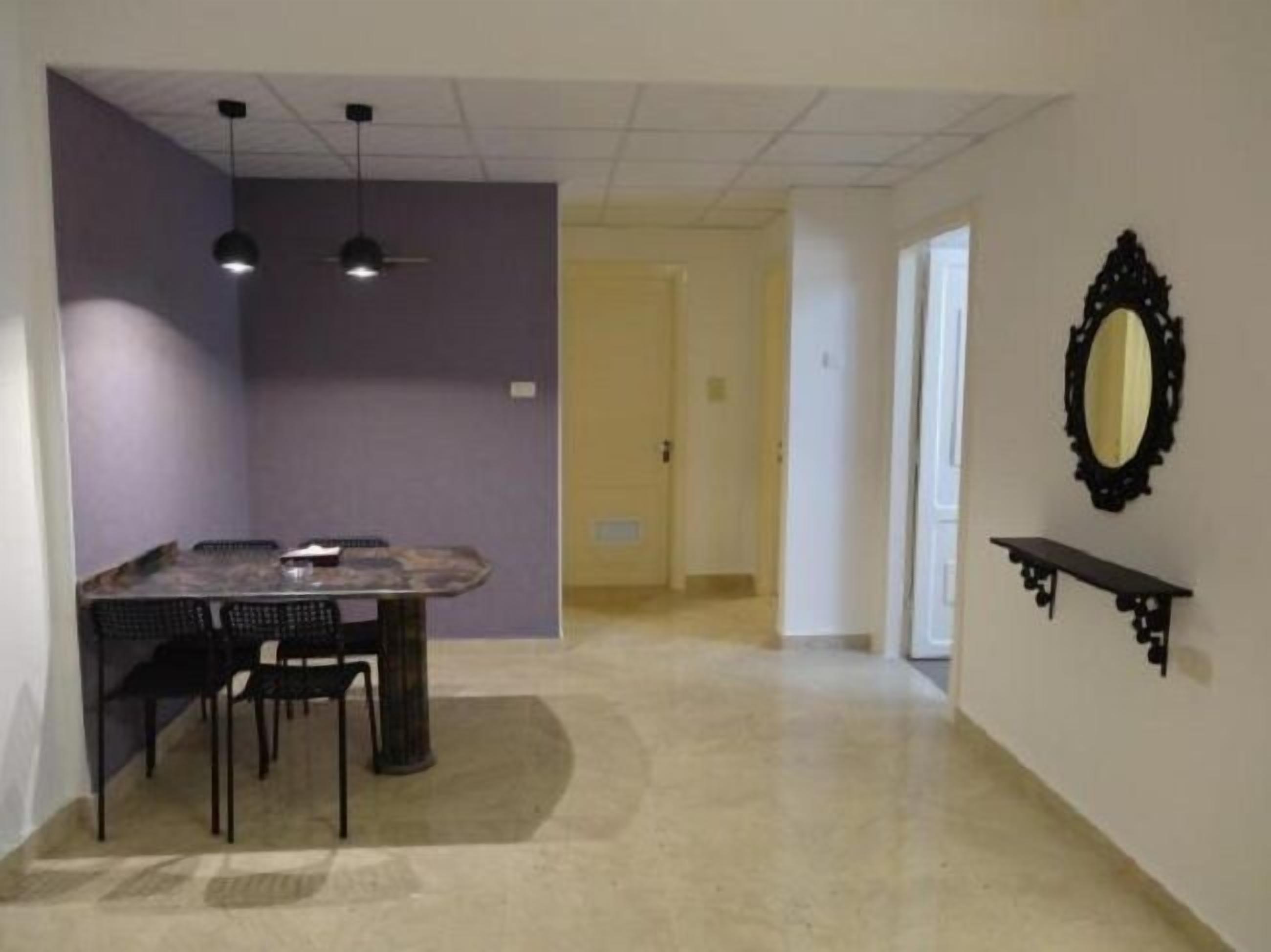 A dining area with a table and chairs, a ceiling fan, and a wall-mounted mirror.