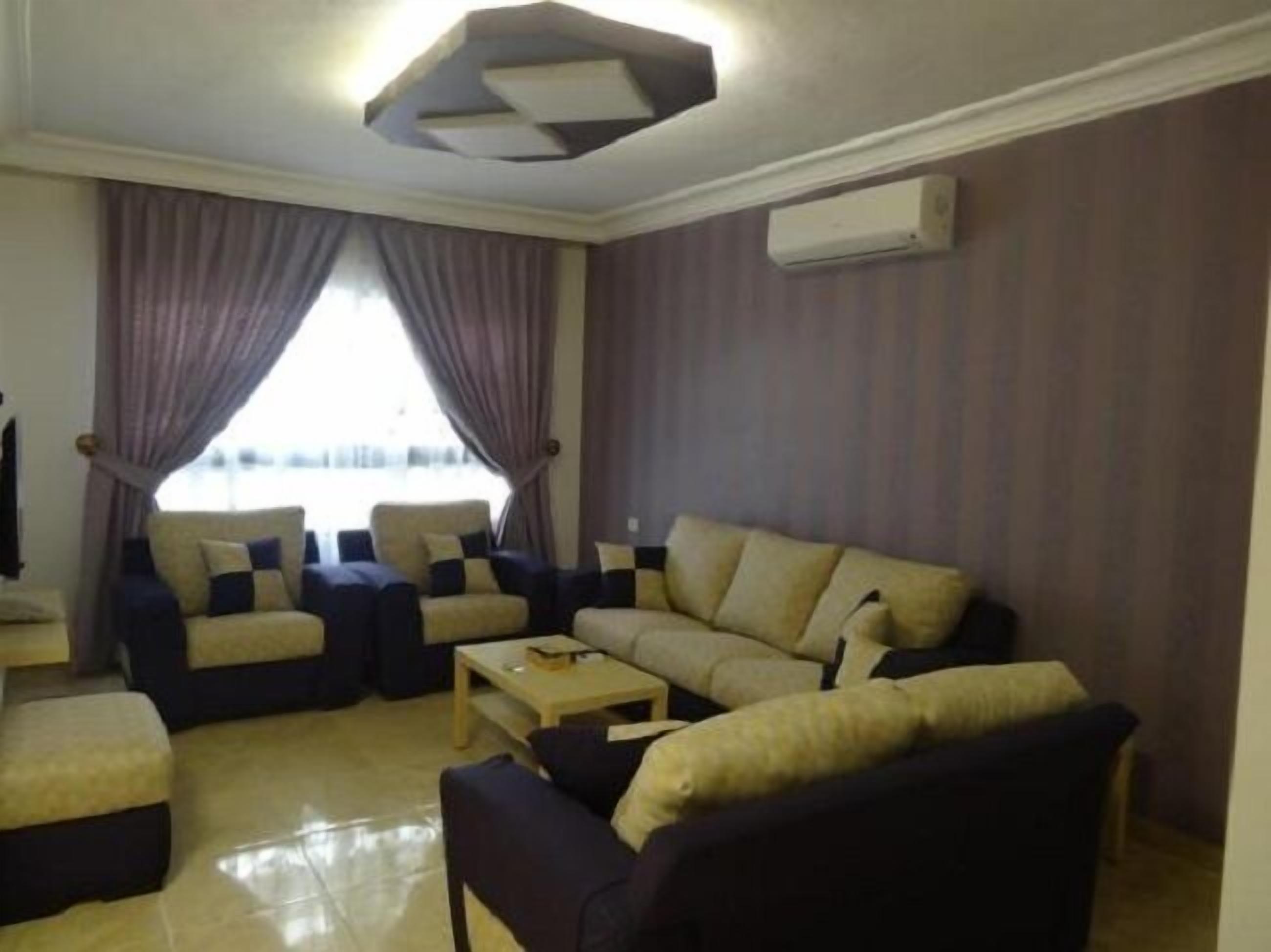 A living room with a sofa set, a coffee table, and a TV.