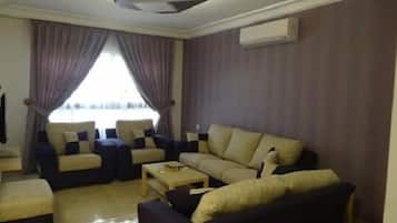 A living room with a sofa set, a coffee table, and a TV.
