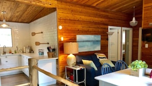 A cabin interior with a kitchen, dining area, and living space. - Quaint, Clean & Updated Cottage- Steps From The Beach. (Port Franks)