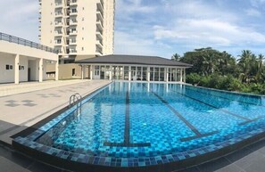Una piscina al aire libre, sillones reclinables de piscina