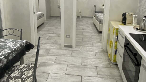 Cocina compacta con comedor, cama y baño pequeño.