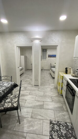 Une cuisine compacte avec un coin repas, un lit et une petite salle de bain.