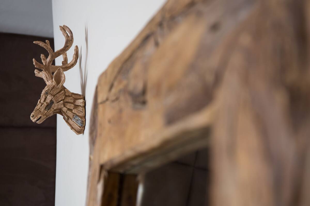 A wooden deer head mounted on a wall.