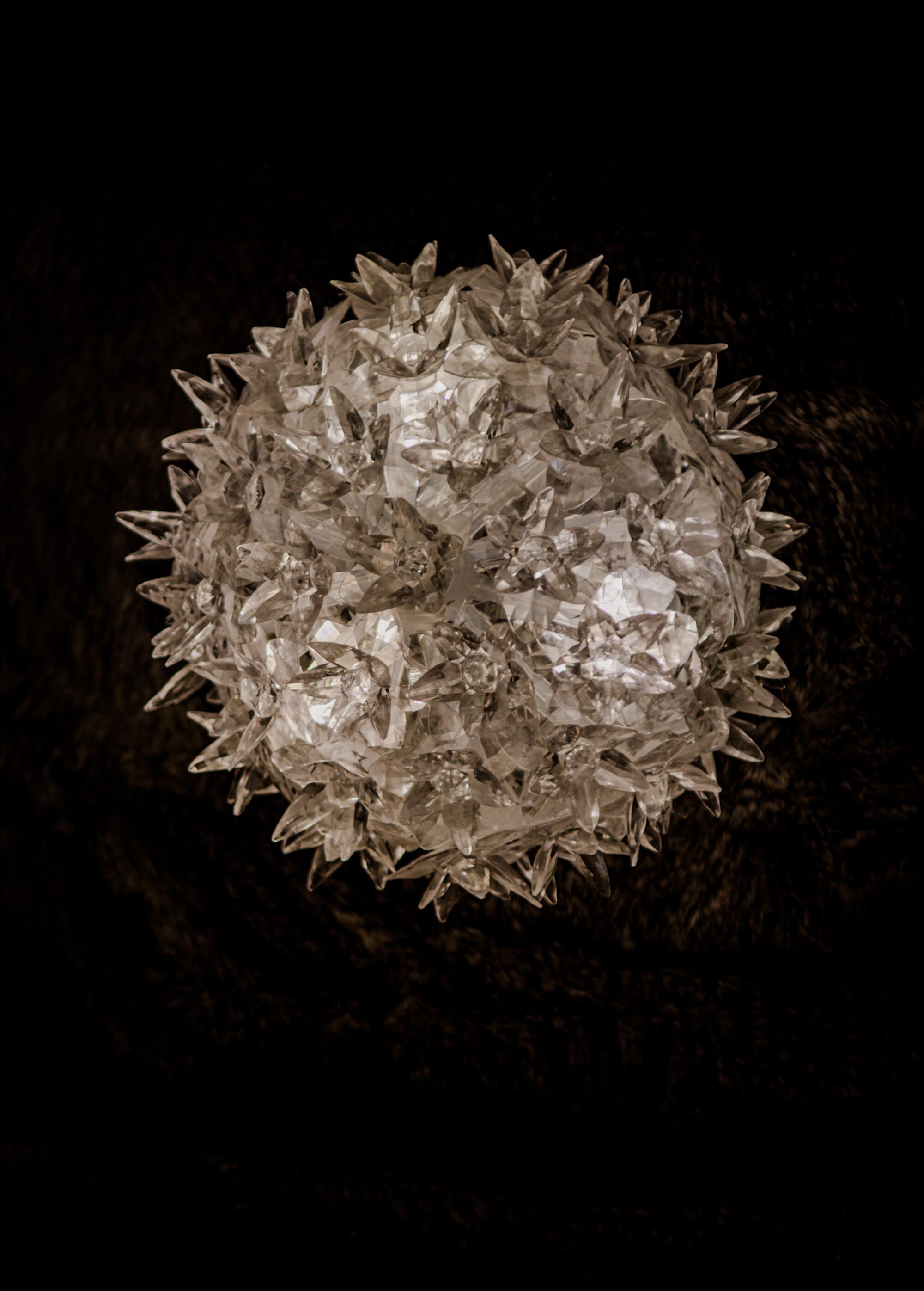 A spherical chandelier with multiple crystal elements.