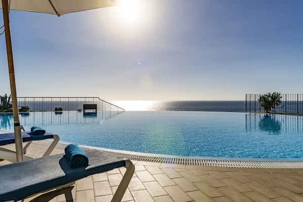 Relax by the pool with a view of the sea.