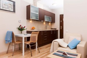 A compact living space with a kitchenette, a dining area, and a seating area.
