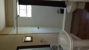 Een douche, handdoeken, zeep, toiletpapier