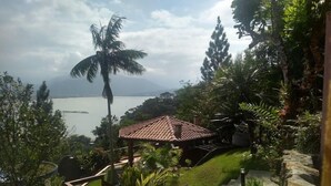 Vista de un resort tropical con cielo despejado, palmeras y una masa de agua al fondo.