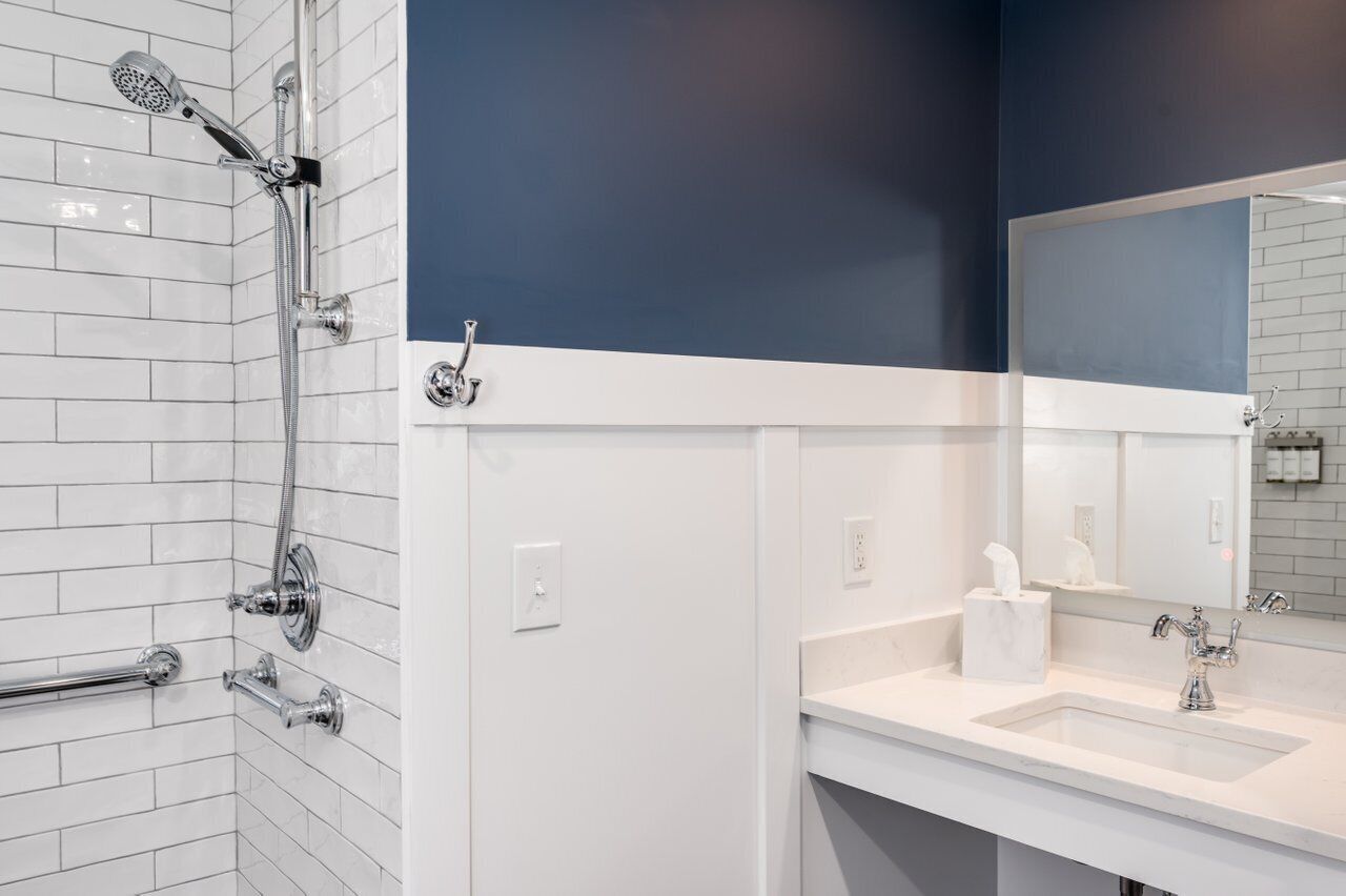 A modern bathroom with a shower, a sink, and a mirror.