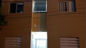 Un edificio de varios pisos con una entrada central, varias ventanas y una puerta visible.