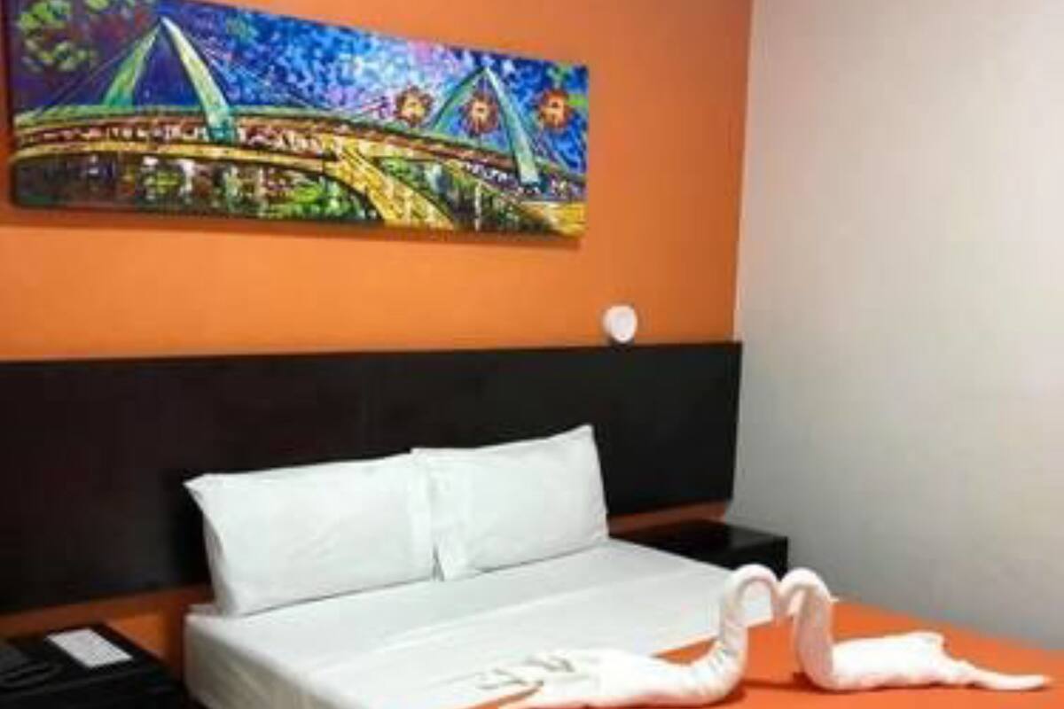 A hotel room with a bed, a nightstand, a painting on the wall, and a tiled floor.
