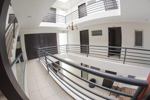 A multi-level residential building with balconies, a chandelier, and a tiled floor. - Hotel Belisario INN (Guadalajara)