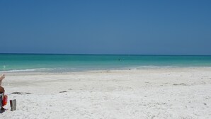 A beach with white sand and clear turquoise water.