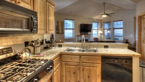 A modern kitchen with wooden cabinets, stainless steel appliances, and a large window overlooking a deck. - Reduced January Rates!  Great Location. 5starReviews. 3 Bed, 2 Bath with Views (Park City)
