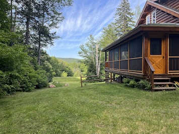 Cabin view of field, waterfalls, and mountains. Screened porch.