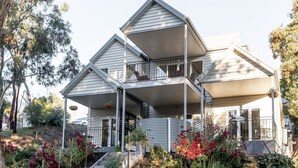 A multi-level house with a balcony and a covered porch area.